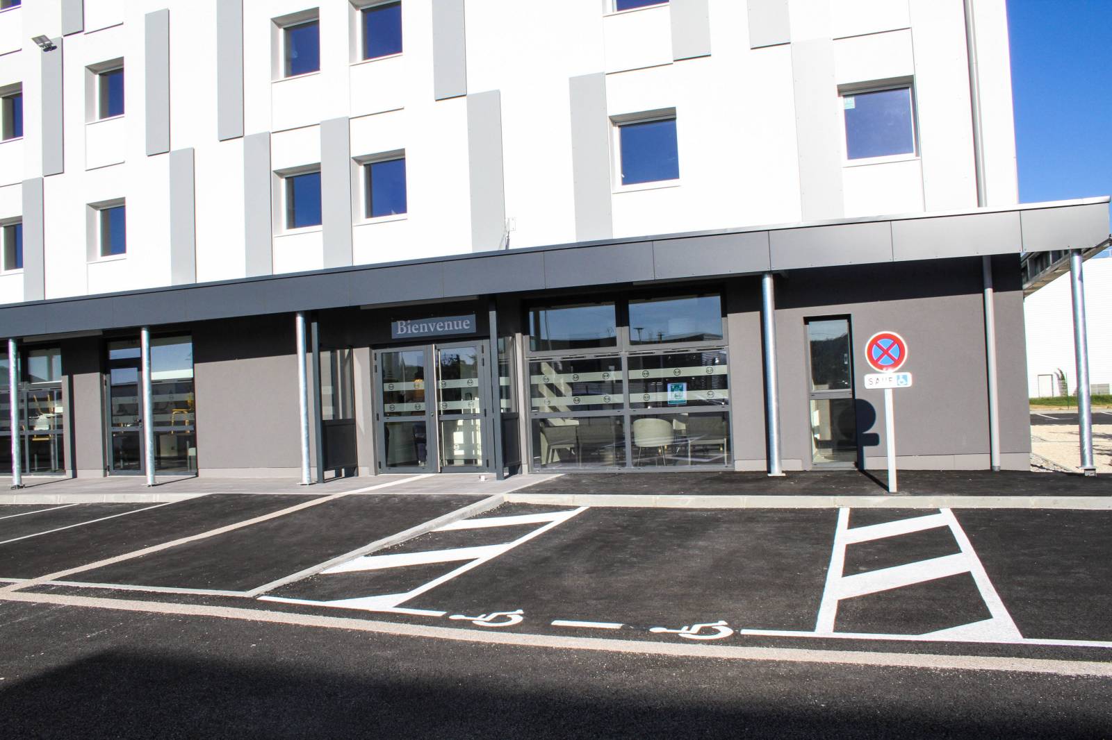Les places de staionnement pour les personnes à mobilité réduite devant l'entrée de l'hôtel B&B Montélimar Sud à Montélimar