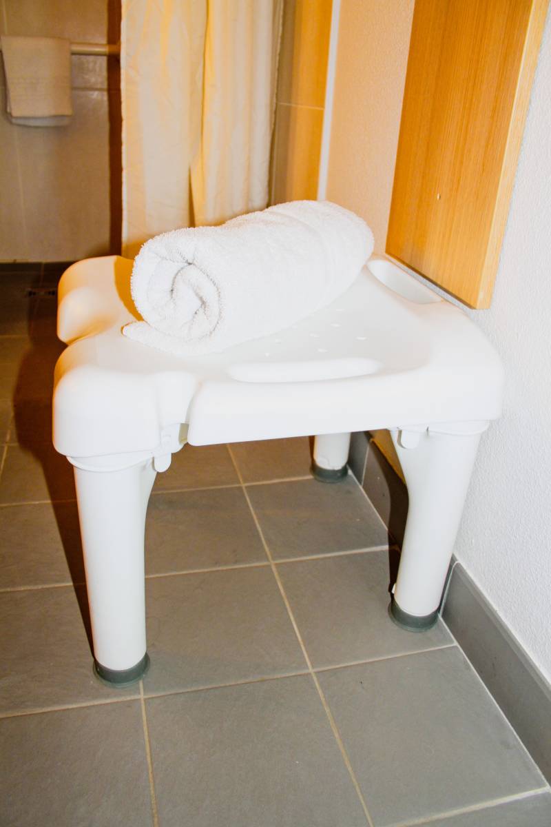 Le tabouret de bain de la chambre PMR de l'hôtel B&B Montélimar Sud