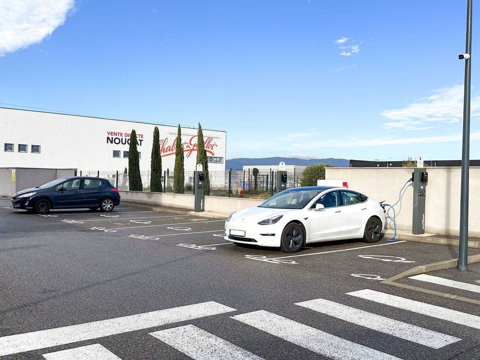 Une voiture électrique branchée sur une des bornes de recharge du B&B HOTEL Montélimar Sud à Montélimar