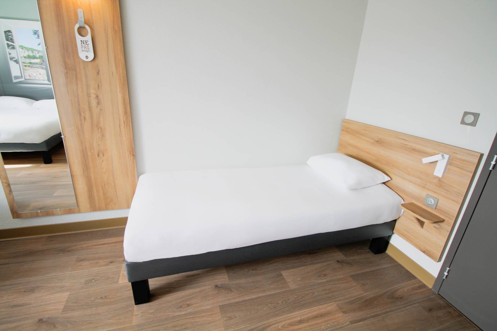 Un lit simple de la chambre pour 4 personnes de l'hôtel pour famille à Montélimar