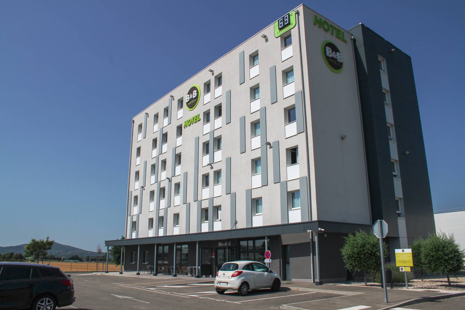 Façade extérieure et parking gratuit du B&B HOTEL Montélimar Sud pour soirée étape.