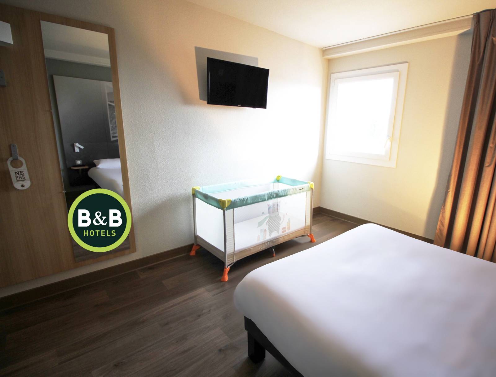 Le lit bébé dans la chambre PMR de l'hôtel B&B Montélimar Sud à Montélimar